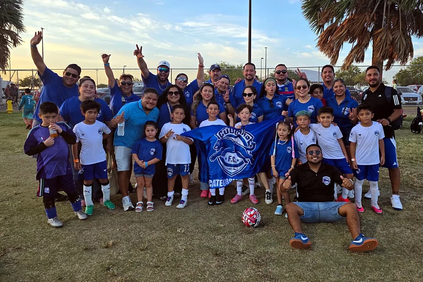 Familias y jugadores celebrando juntos al atardecer